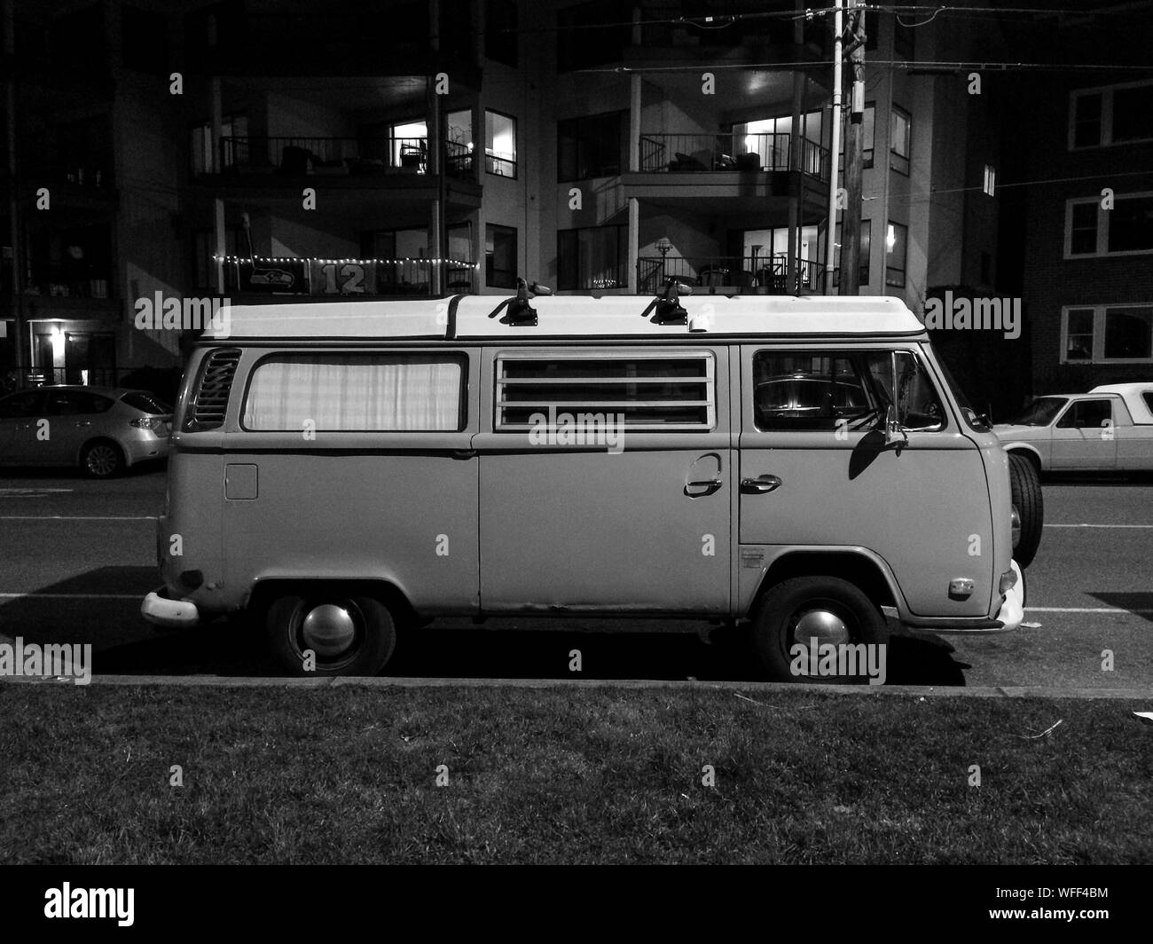 Micro autobús estacionado en frente del edificio por la noche Foto de stock