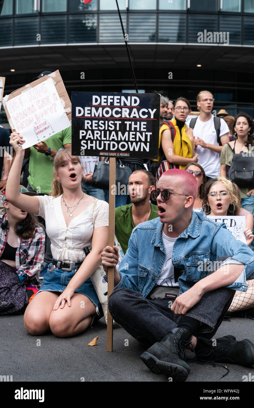 31 Aug 2019 - Londres, Reino Unido. Un manifestante sostiene un cartel Anti-Brexit 'Defend la democracia. Resistir el Parlamento Shutdown" mientras que el bloqueo de la carretera. Foto de stock