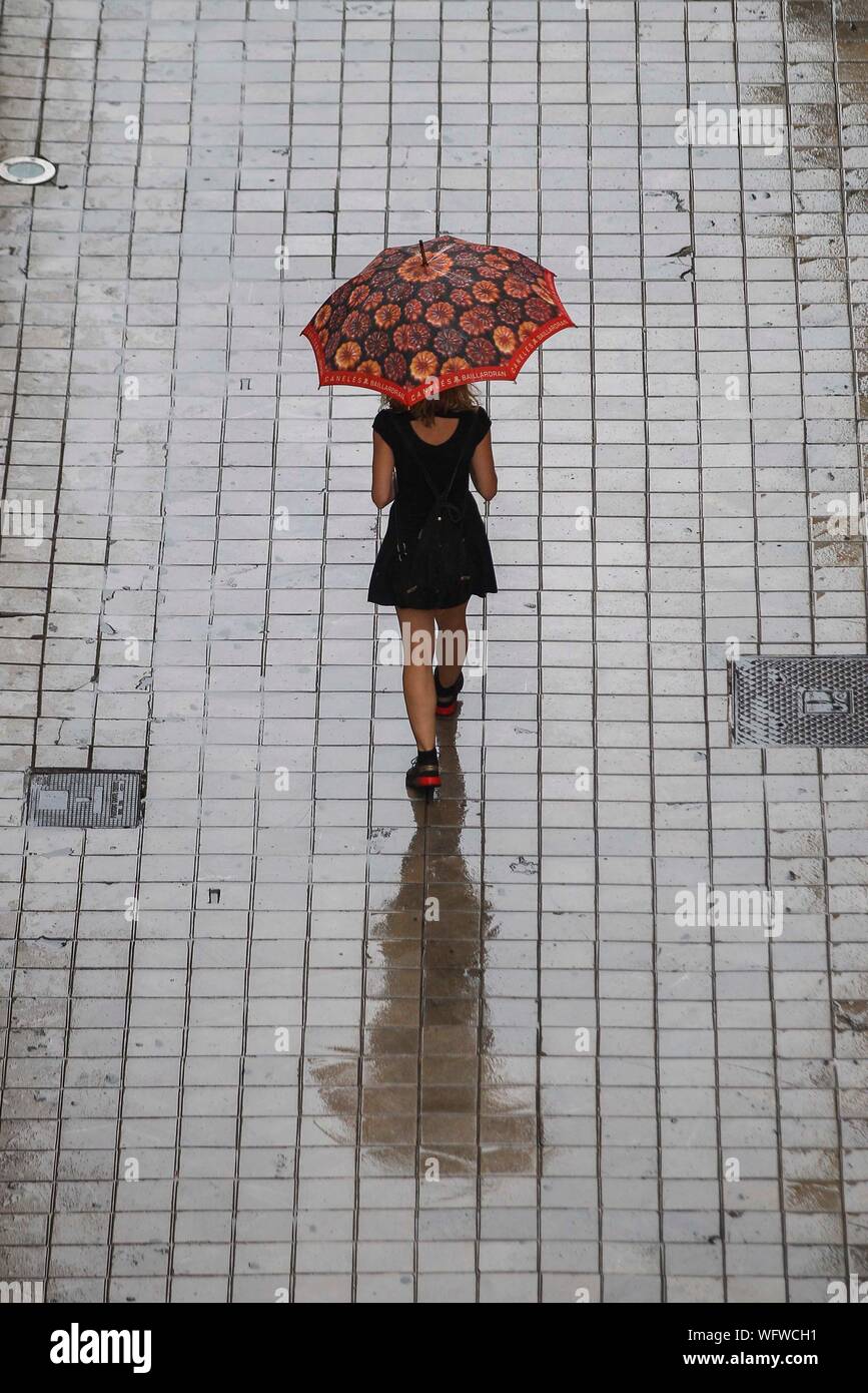 Una niña con paraguas se protege de la lluvia un día de verano en Valencia Fotografía de stock - Alamy