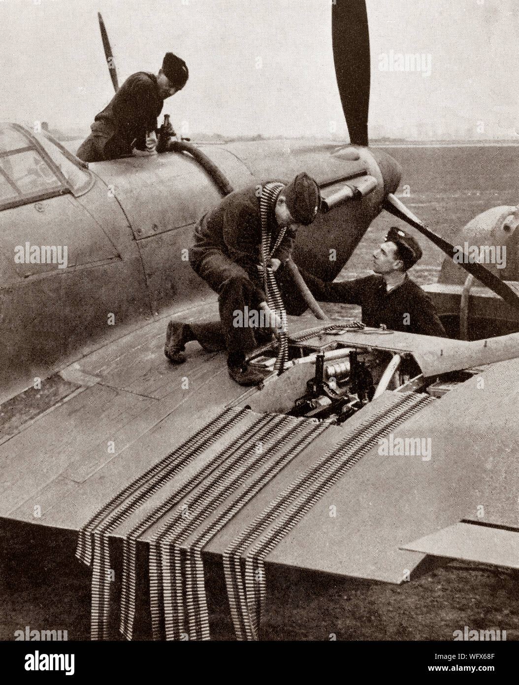 Groundcrew cargando munición en el ala de un huracán, los británicos Hawker Solo asiento con aviones de combate de la RAF. Se vio ensombrecida en la conciencia pública por el Supermarine Spitfire el papel durante la Batalla de Gran Bretaña en 1940, pero el Huracán infligió el 60 por ciento de las pérdidas sufridas por la Luftwaffe en la contratación, y luchó en todos los principales teatros de la Segunda Guerra Mundial. Foto de stock