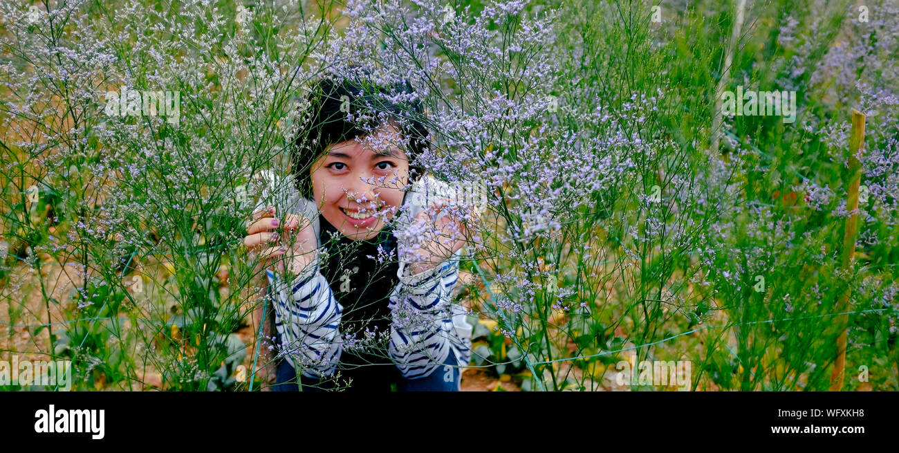 Retrato de mujer vistos a través de flores púrpura Foto de stock