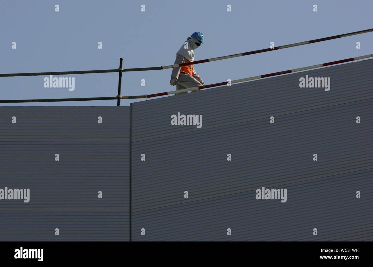 Trabajador de la construcción caminando en el Mall de los Emiratos. Foto de stock