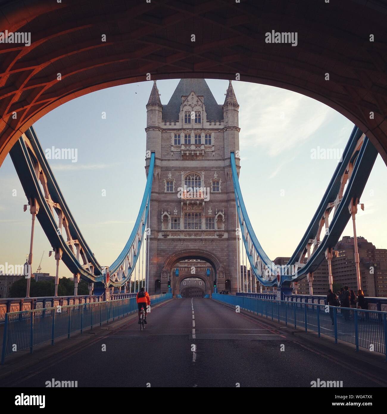 Vista trasera del ciclista bicicleta Equitación en el Tower Bridge contra el cielo en la mañana Foto de stock