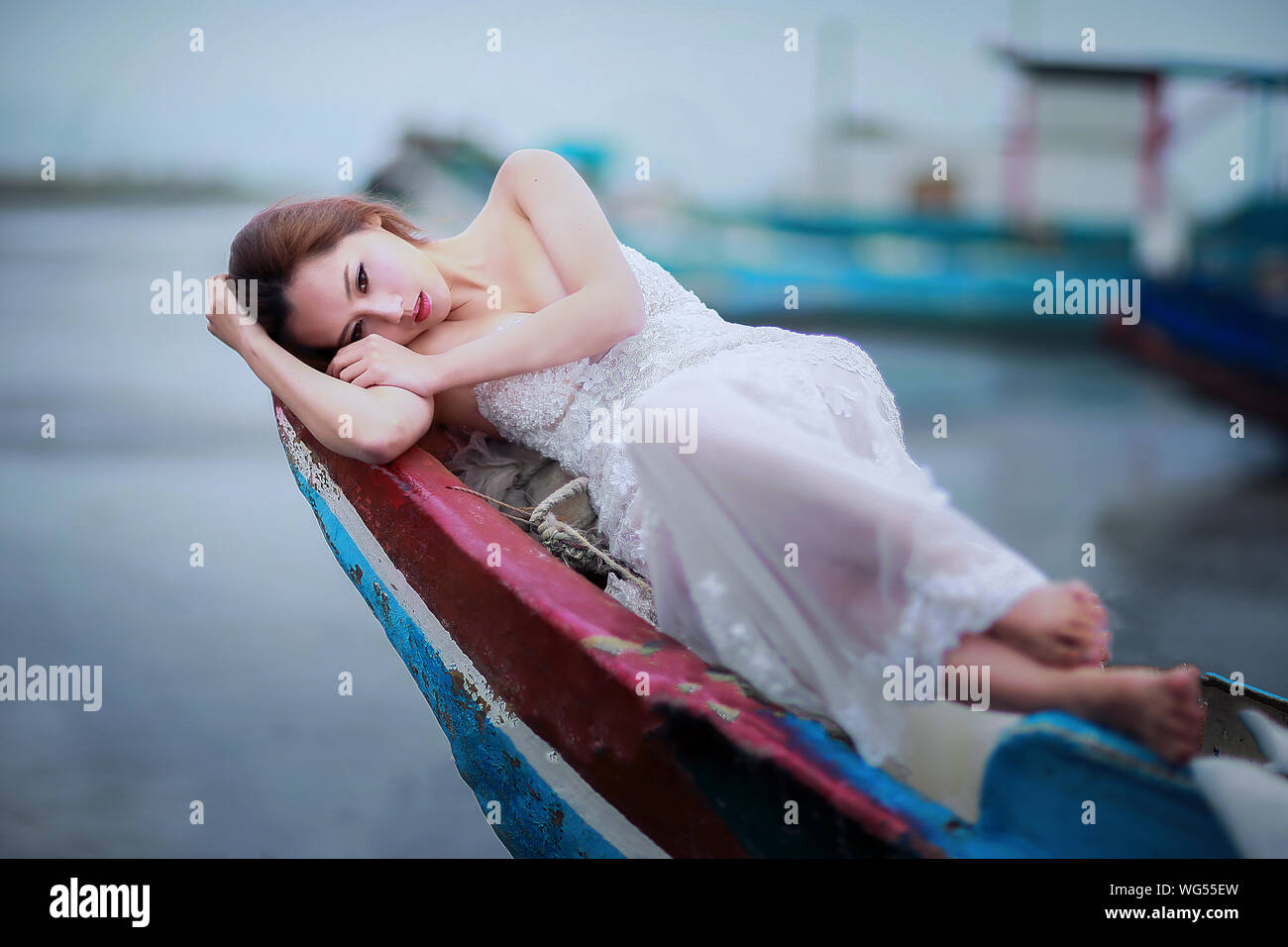Modelo de mujer hermosa en el vestido de noche blanco acostado en el barco en el mar Fotografía de stock - Alamy Modelo de mujer hermosa en el vestido de noche blanco acostado en el barco en el mar Fotografía de stock - Alamy