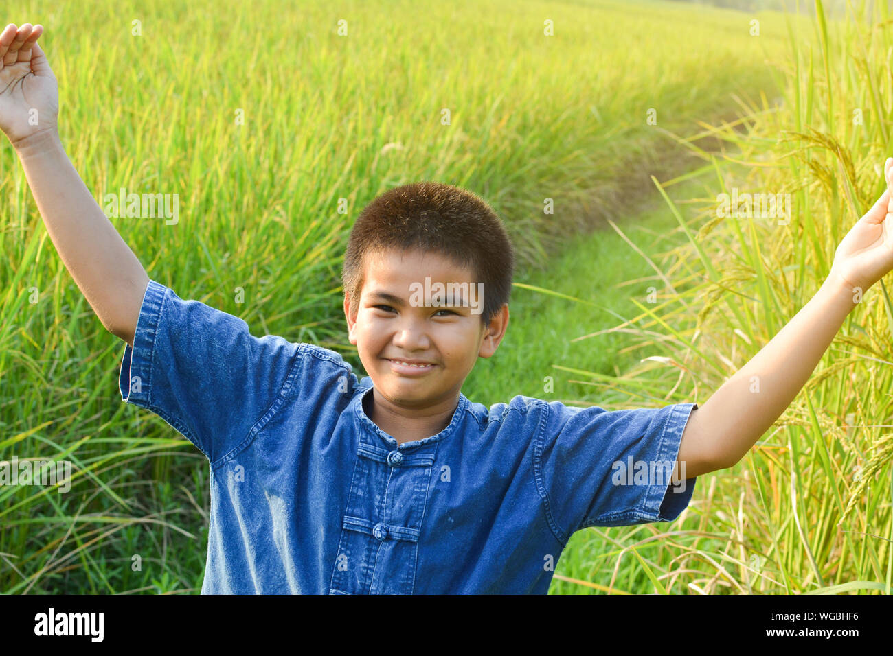 Retrato de muchacho feliz de pie con los brazos extendidos en la granja Foto de stock