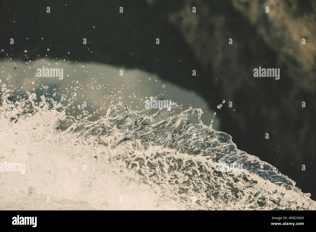 Salpicadura de agua fresca con gotas capturadas en el aire con la superficie del río color turquesa en el fondo Foto de stock