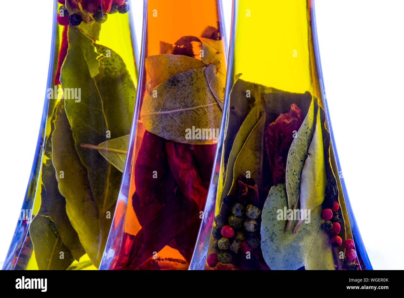 High Key tiros de tres botellas de aceite de oliva infundido con una mezcla de hierbas y especias. Foto de stock