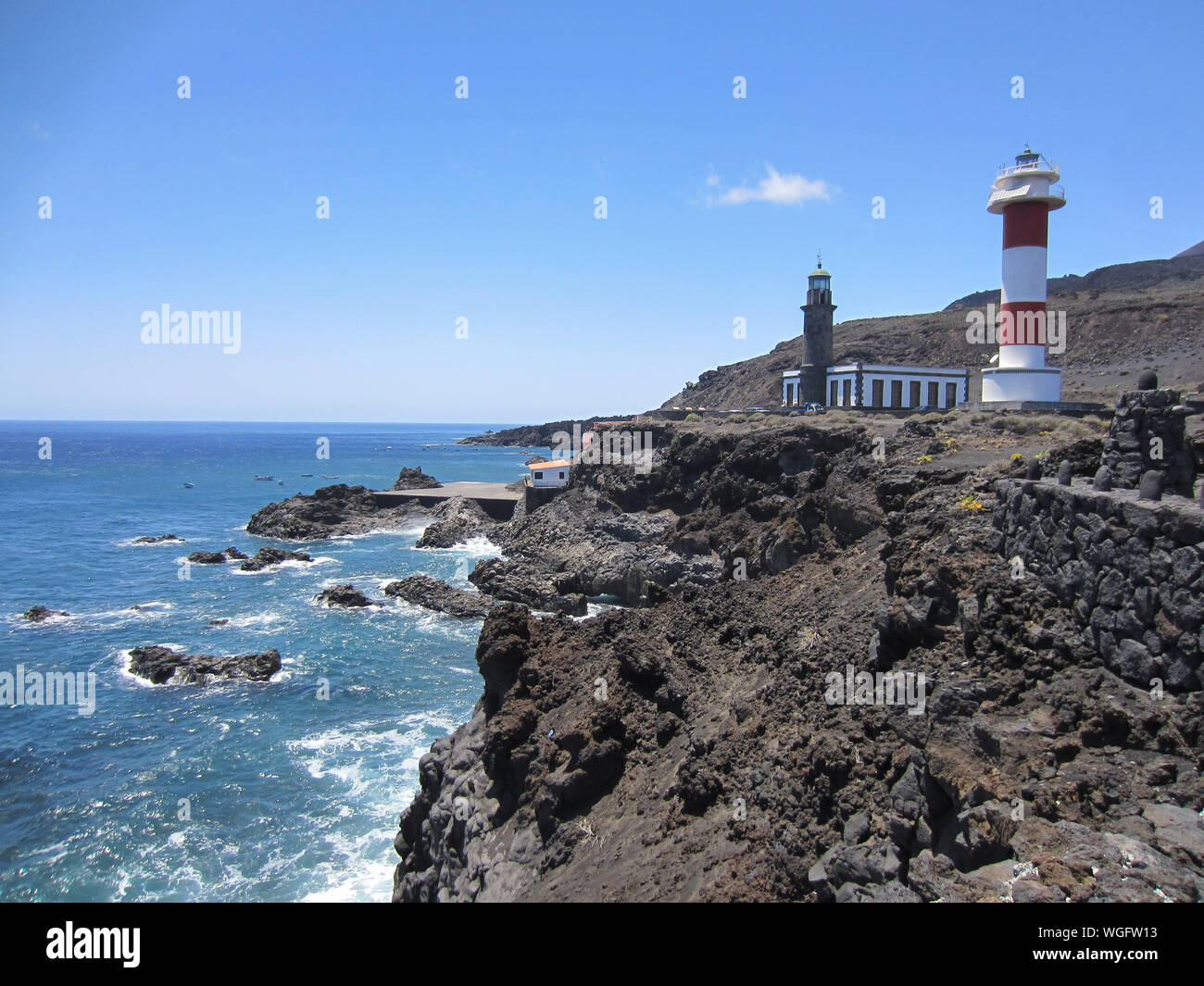 Faro en la playa contra el cielo azul claro Foto de stock