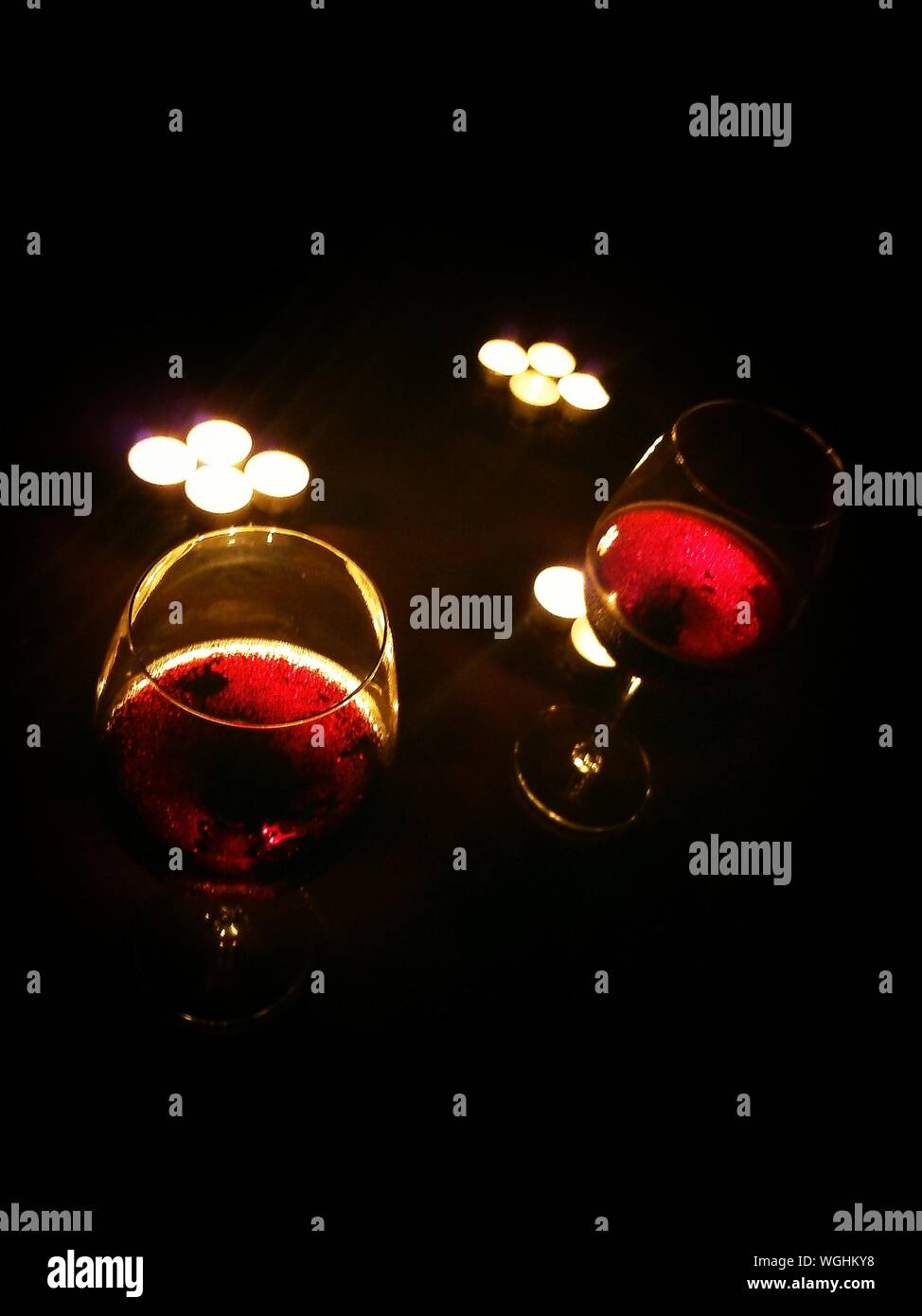 Copas de vino rojo y la luz de las velas Foto de stock