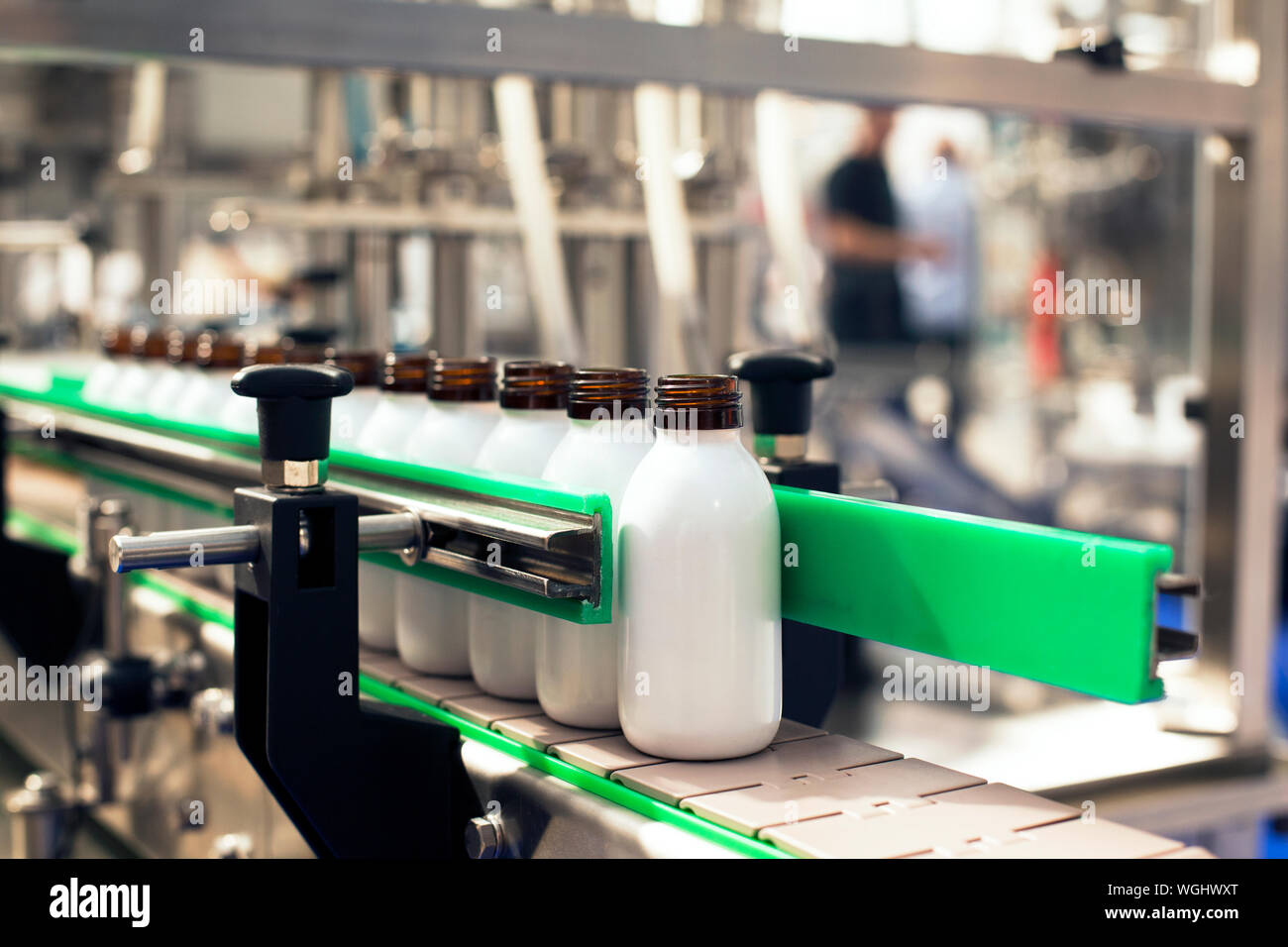 Close-up de botellas sobre la cinta transportadora en la fábrica Fotografía  de stock - Alamy