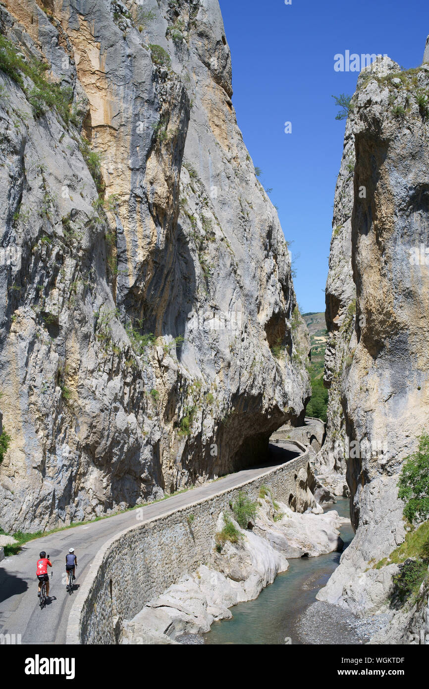 Dos ciclits entrando en un profundo y estrecho cañón. Pista de Barles, Valle de Bés, Alpes de Alta Provenza, Francia. Foto de stock