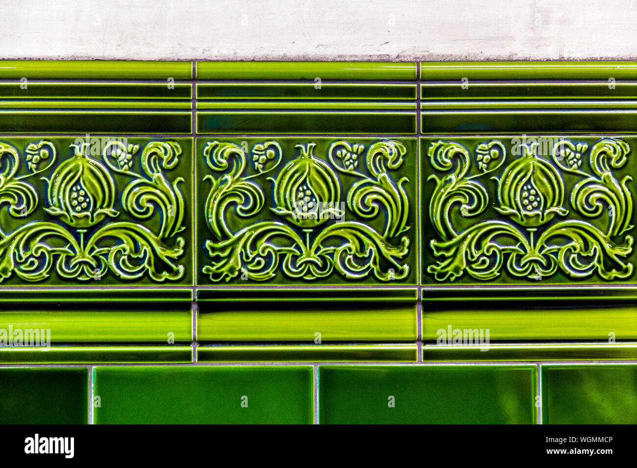 Detalle de azulejos decorativos de cerámica verde con un friso de hojas de acanto en la estación de metro de Chalk Farm, Londres, Reino Unido. Foto de stock