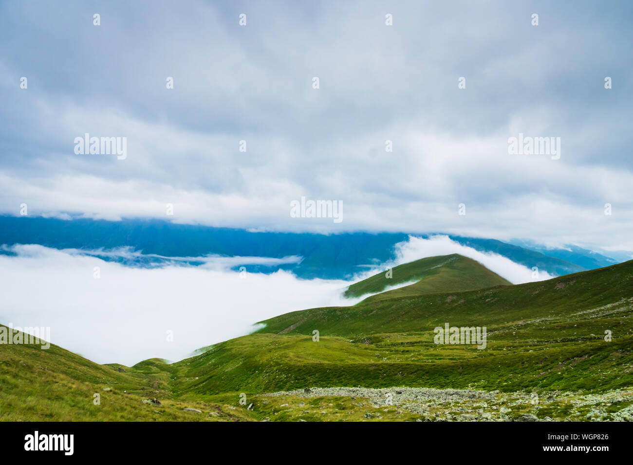 Kazbegi, Georgia - Monte Kazbegi paisaje con nubes dramáticas en la ruta de trekking y senderismo. Foto de stock