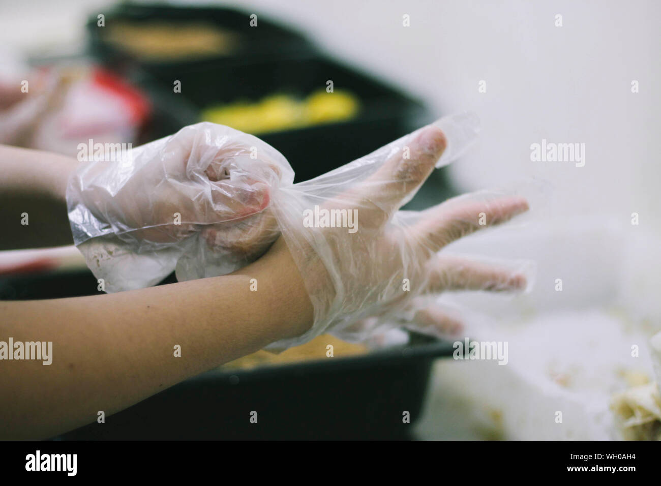 Close-up de recortado manos usando guantes de plástico Foto de stock