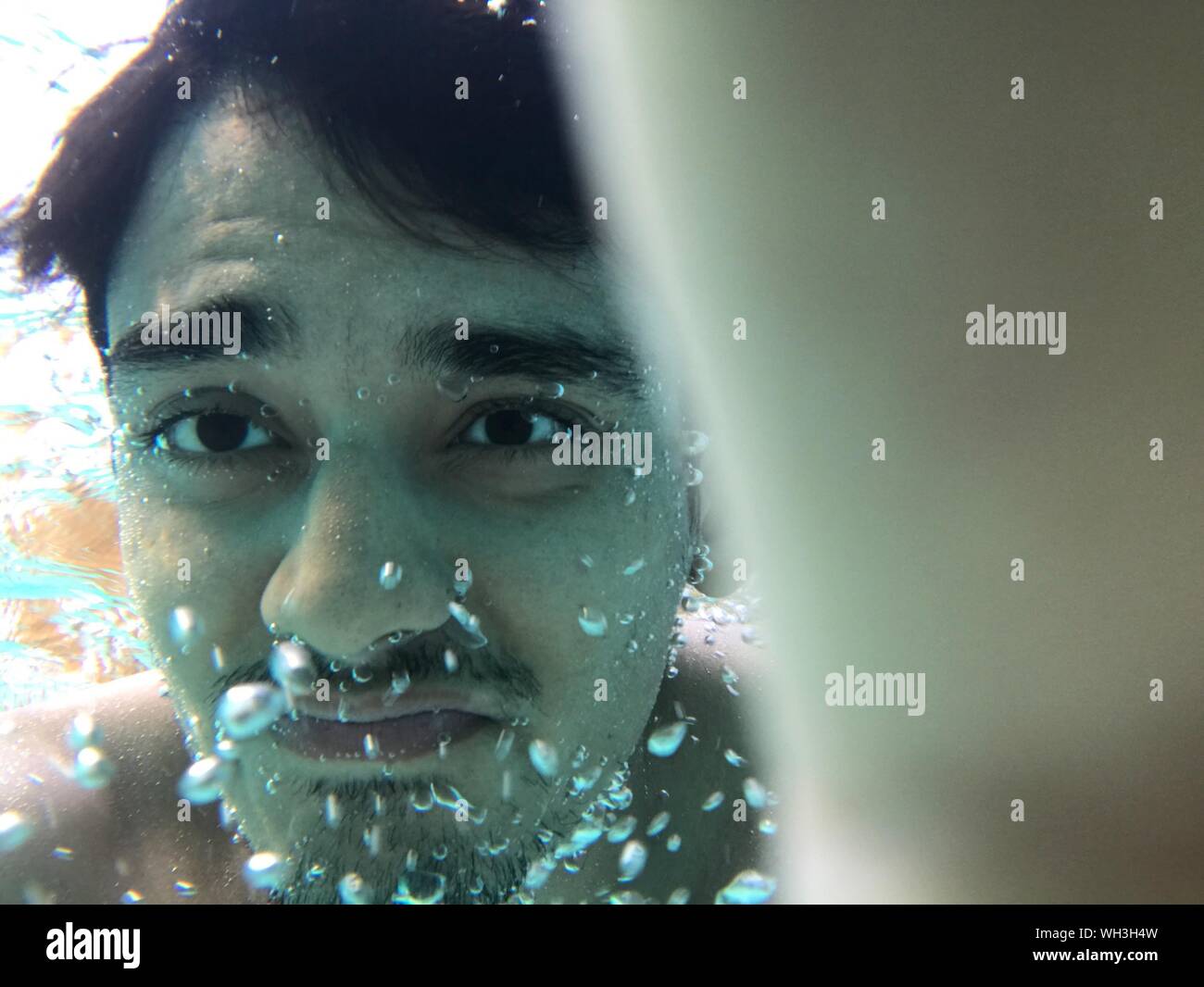 Imagen Submarina del hombre nadar en piscina Foto de stock
