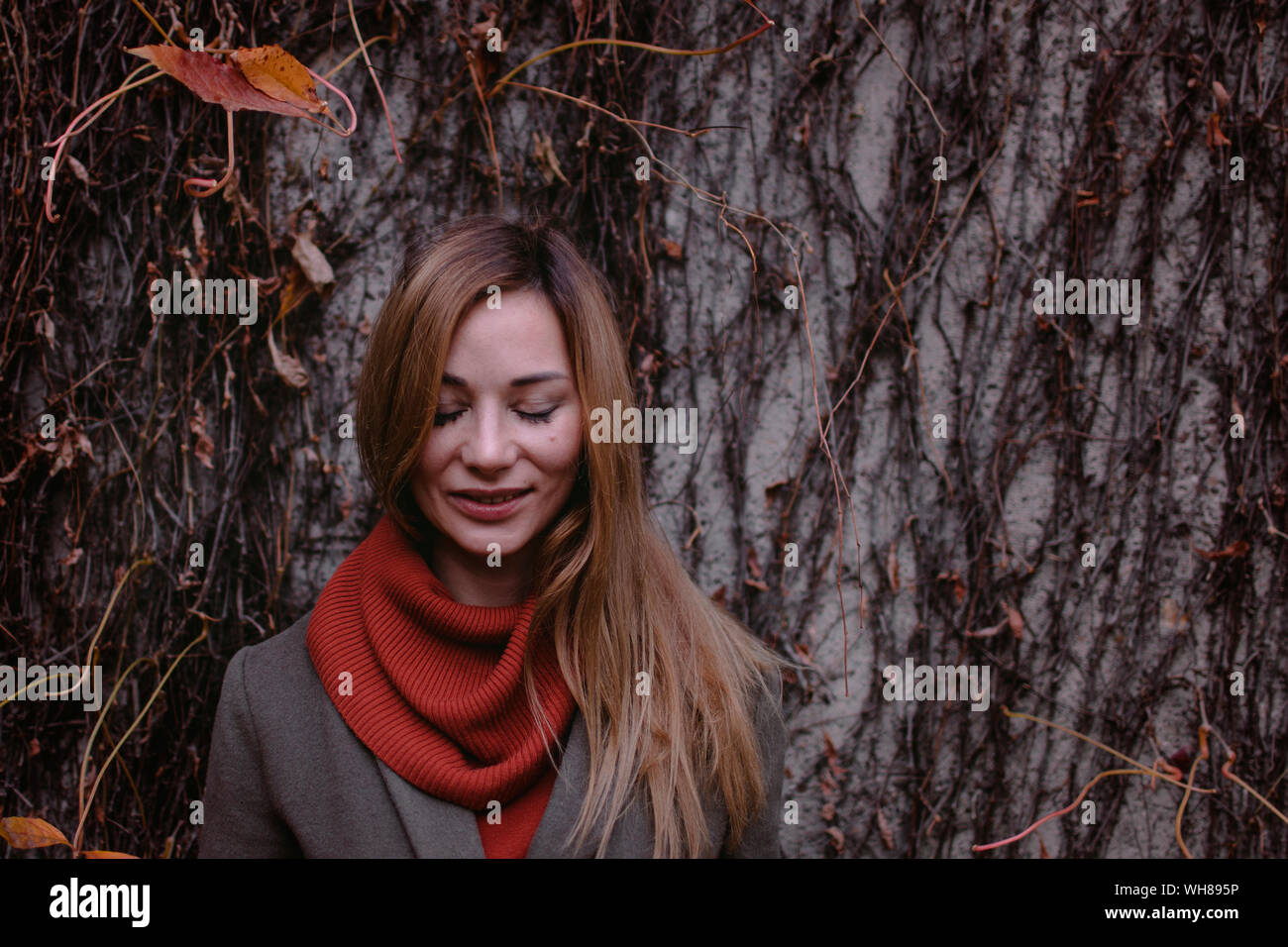 Retrato de mujer sonriente con los ojos cerrados en otoño Foto de stock
