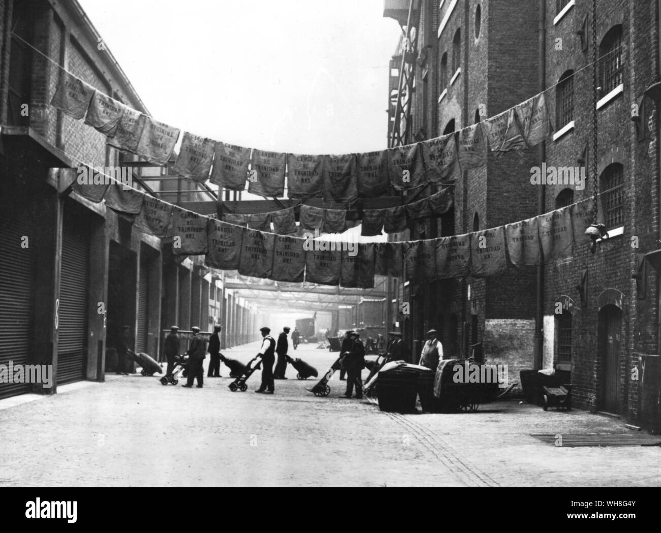 Azúcar en bolsas colgadas a secar, North Quay, West India Docks, 1900. Foto de stock