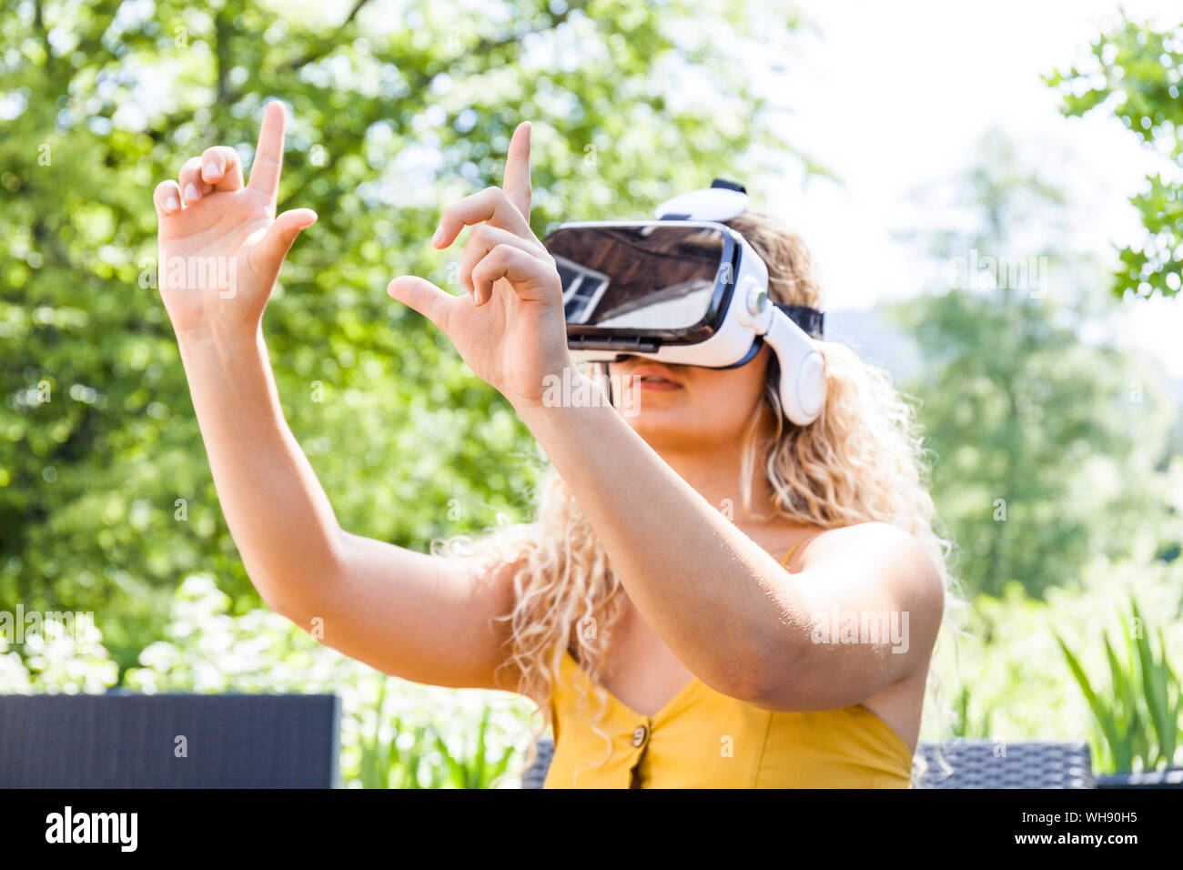 Joven Mujer rubia con gafas de realidad virtual en el exterior Foto de stock