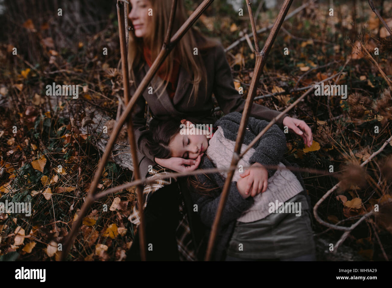 Retrato de niña con la cabeza en el regazo de su madre en la naturaleza autumnul Foto de stock