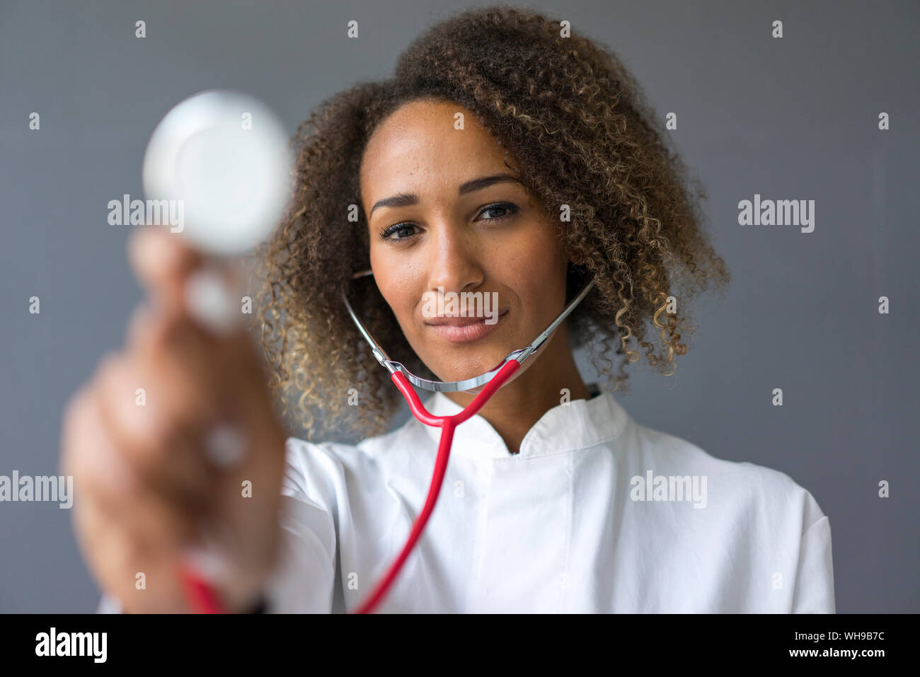 Retrato de joven médico utilizando un estetoscopio para examen Foto de stock