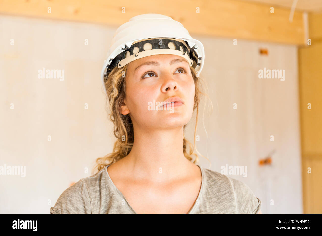 Mujer joven comprobando la construcción de una nueva casa de madera Foto de stock