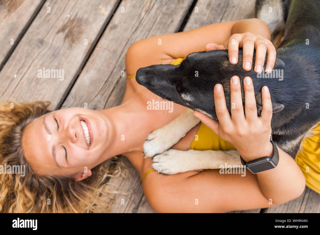 Husky pastor mongrel dog y su amante acostado sobre la plancha de madera Foto de stock