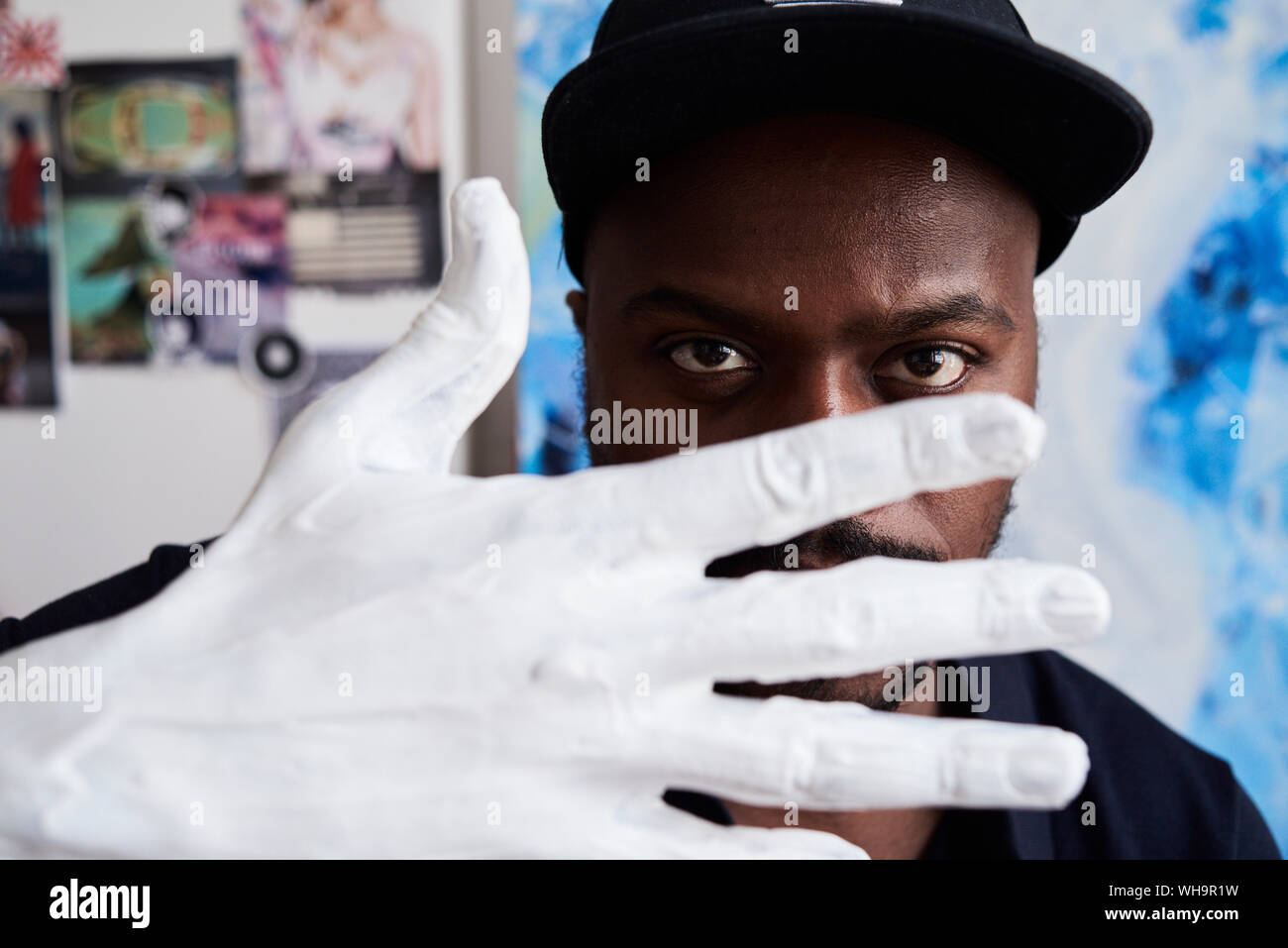 Artista negro a través de dedos de las manos pintadas de blanco en su studio Foto de stock