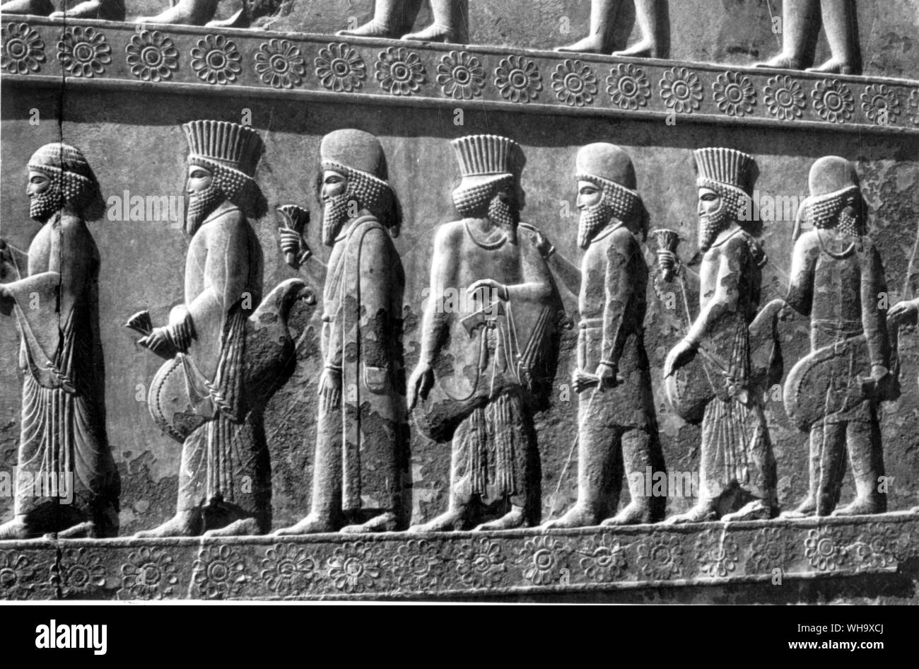 Los persas llevan largas túnicas y sombreros de copa estriada; los medos desgaste coates y pantalones. Foto de stock