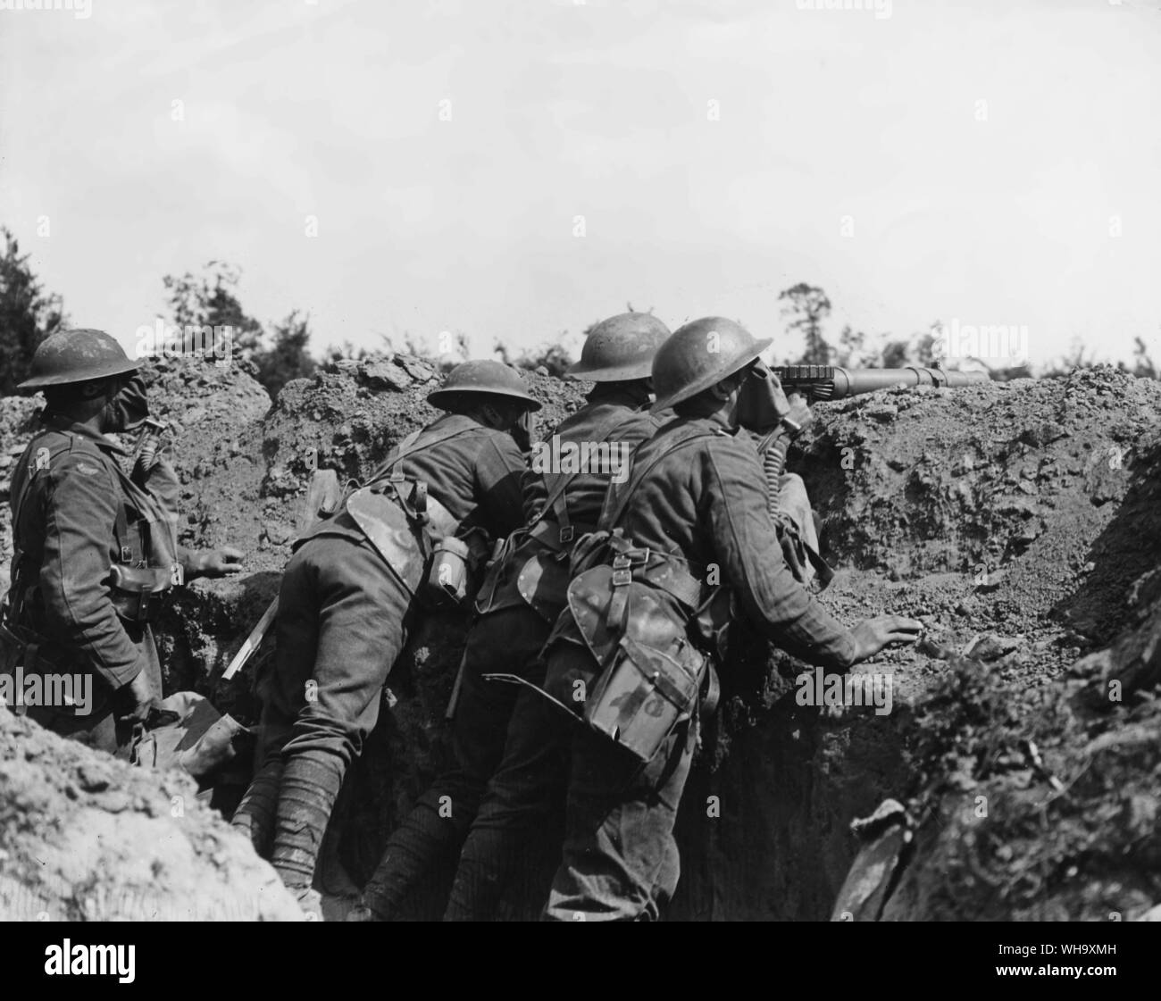 WW1: las tropas aliadas en una zanja. Los soldados británicos con una ametralladora ponerse máscaras antigás. Foto de stock