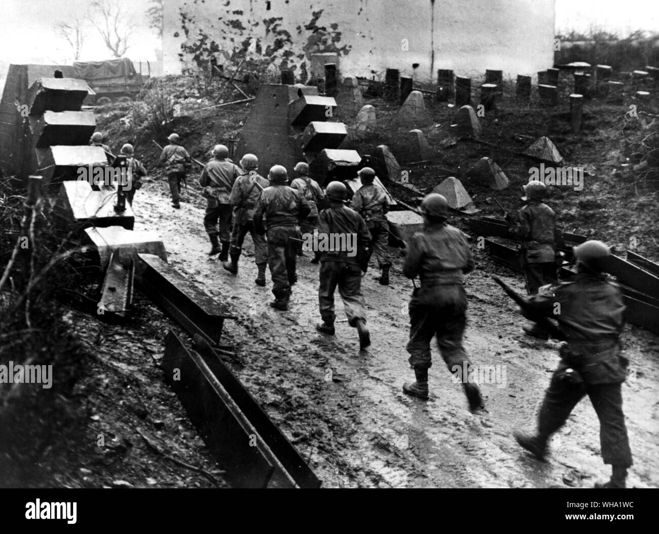 WW2: Nosotros infantes pasan a través de una correa de formidables los dientes del dragón a medida que avanzan a través de la ruptura de la línea Sigfrido en Habscheid, Alemania. Habscheid SW está a 8 millas de la carretera cruce de Prum, el cual fue incautado 13 de febrero de 1945 por las fuerzas estadounidenses. Foto de stock