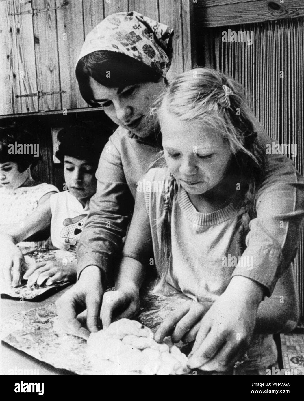Las niñas reciben instrucción en lo jala. Un dulce, eggy, amarillo, normalmente el pan trenzado, el cual es servido en Shabbat y días festivos Foto de stock