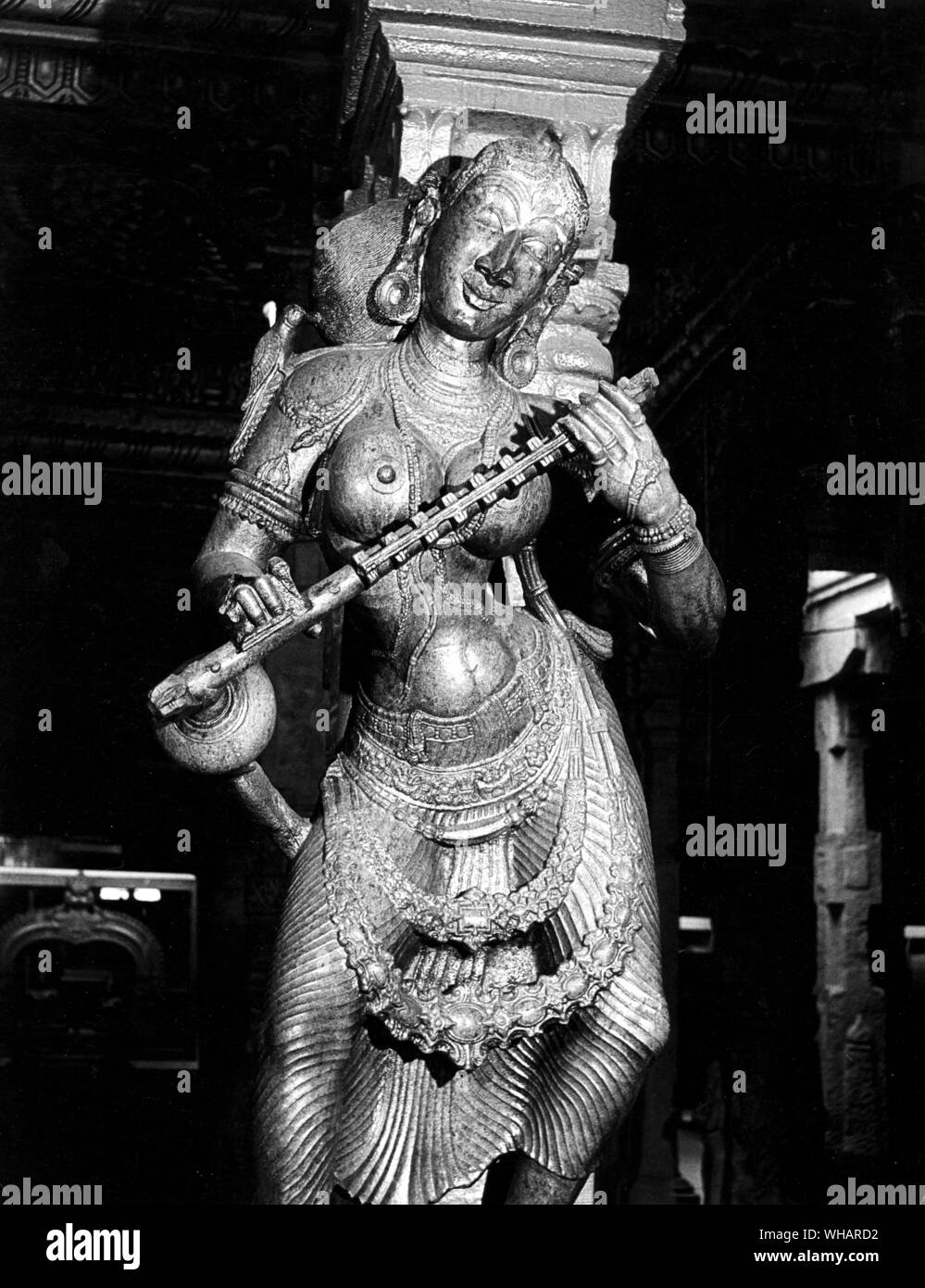 Madunai. Saraswathy diosa de la sabiduría con la Veena. Saraswati, la diosa de la sabiduría, el arte y la música es la hija del señor Shiva y de la Diosa Durga. Se cree que la diosa Saraswati dota a los seres humanos con los poderes de la voz, la sabiduría y el aprendizaje. Ella tiene cuatro manos que representan cuatro aspectos de la personalidad humana en el aprendizaje: la mente, el intelecto, la lucidez mental y el ego. Ella tiene las sagradas escrituras en una mano y un loto - el símbolo del conocimiento verdadero - en el segundo. Con sus dos manos ella reproduce la música del amor y de la vida en un instrumento de cuerda llamado veena. Ella está vestida de blanco - el Foto de stock