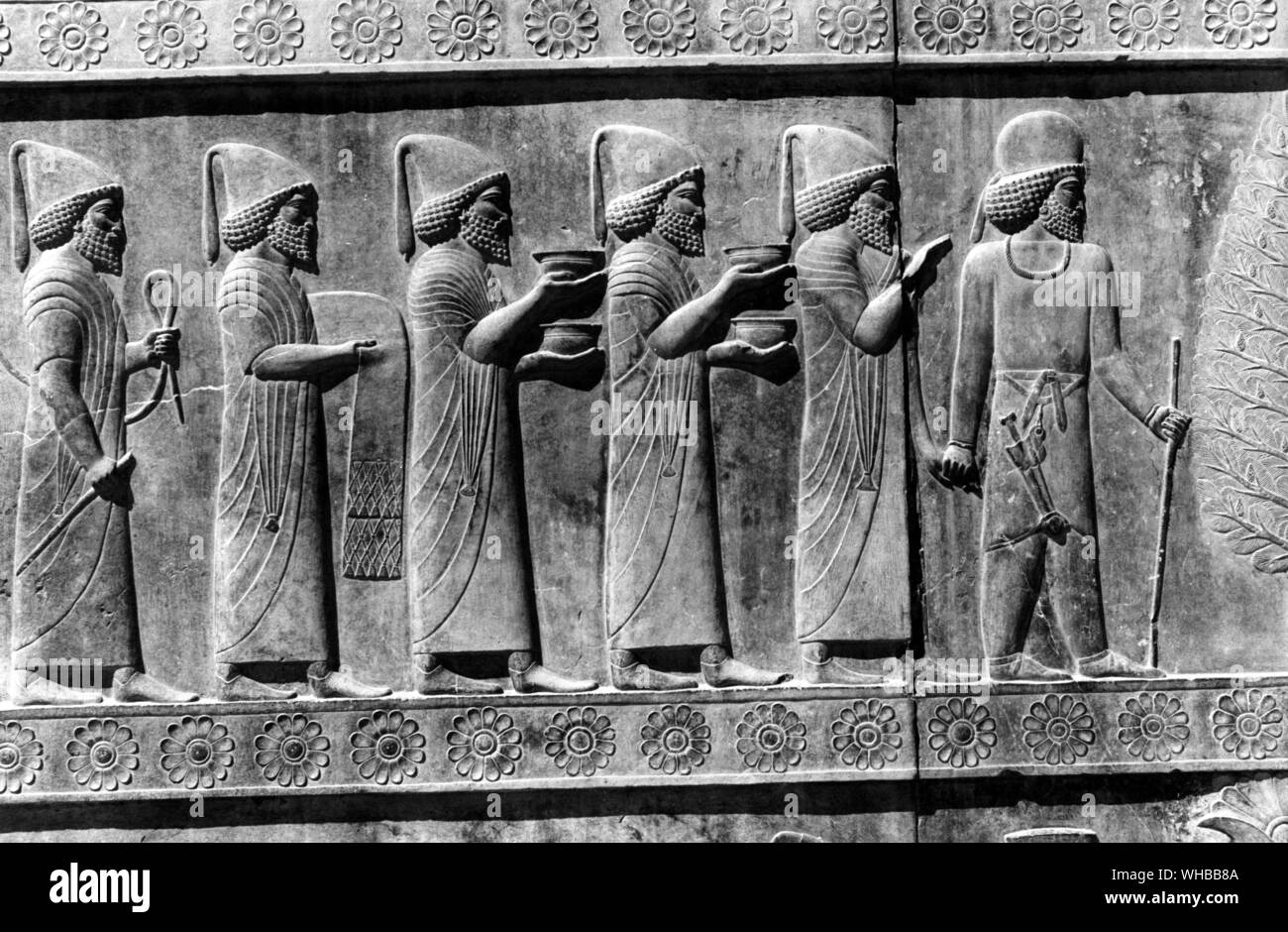 Apadana Palace , Persepolis : socorro persa en la escultura de funcionarios llevando regalos , Irán Foto de stock