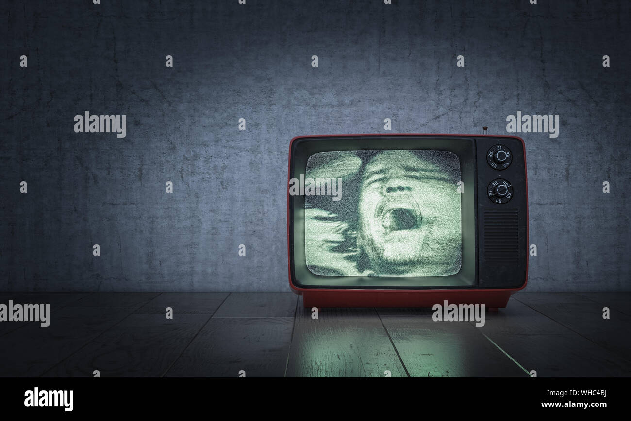 El hombre grita dentro de un viejo televisor en el suelo concepto de película de terror. Foto de stock
