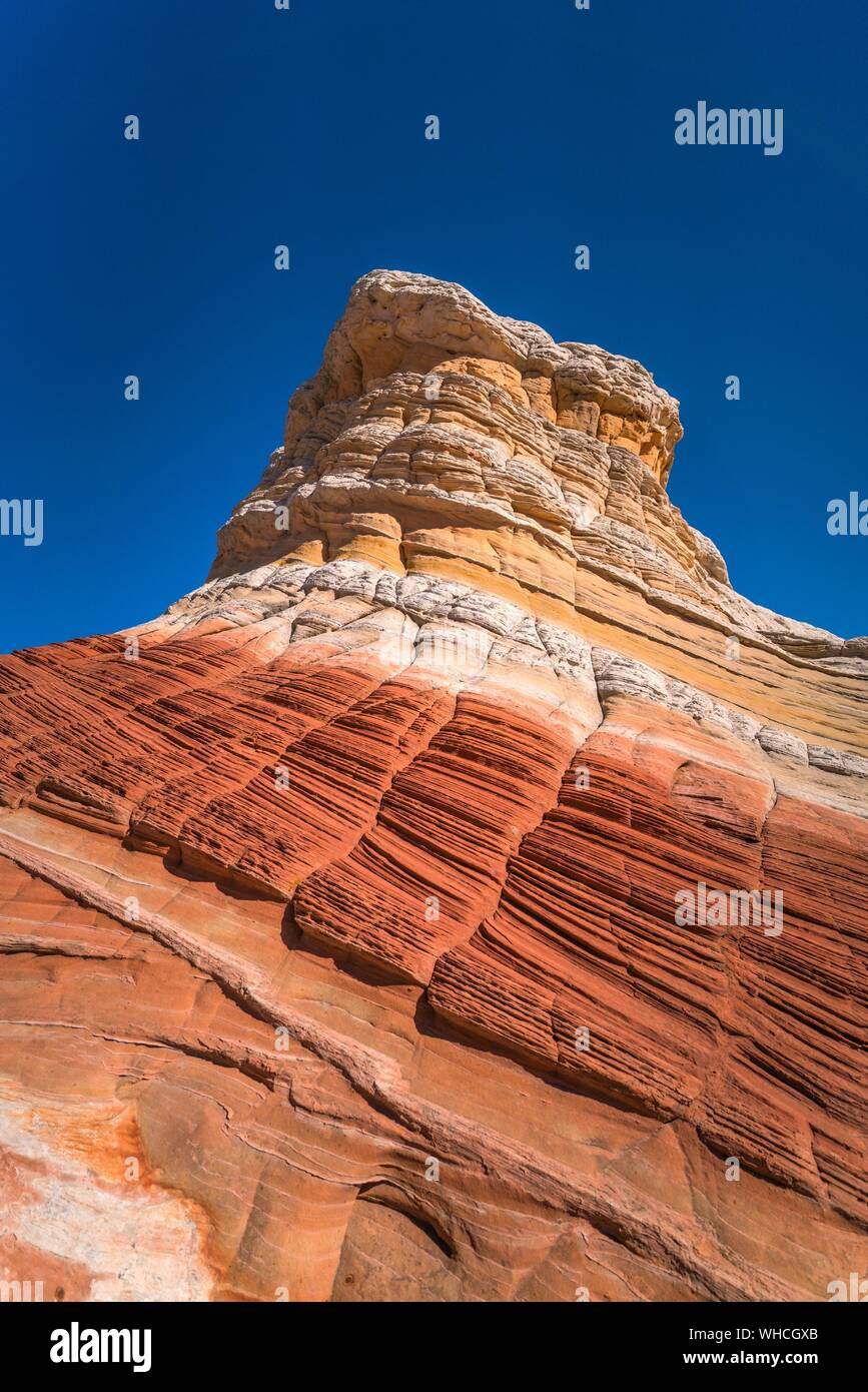 Ángulo de visión baja de formaciones de roca contra el cielo azul claro en blanco Pocket Foto de stock