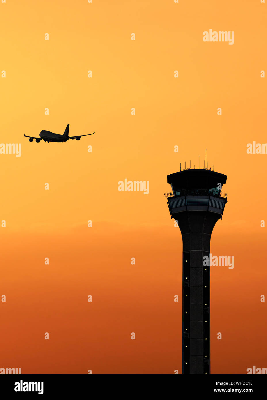 Torre de control del tráfico aéreo con un avión despegando al atardecer Foto de stock
