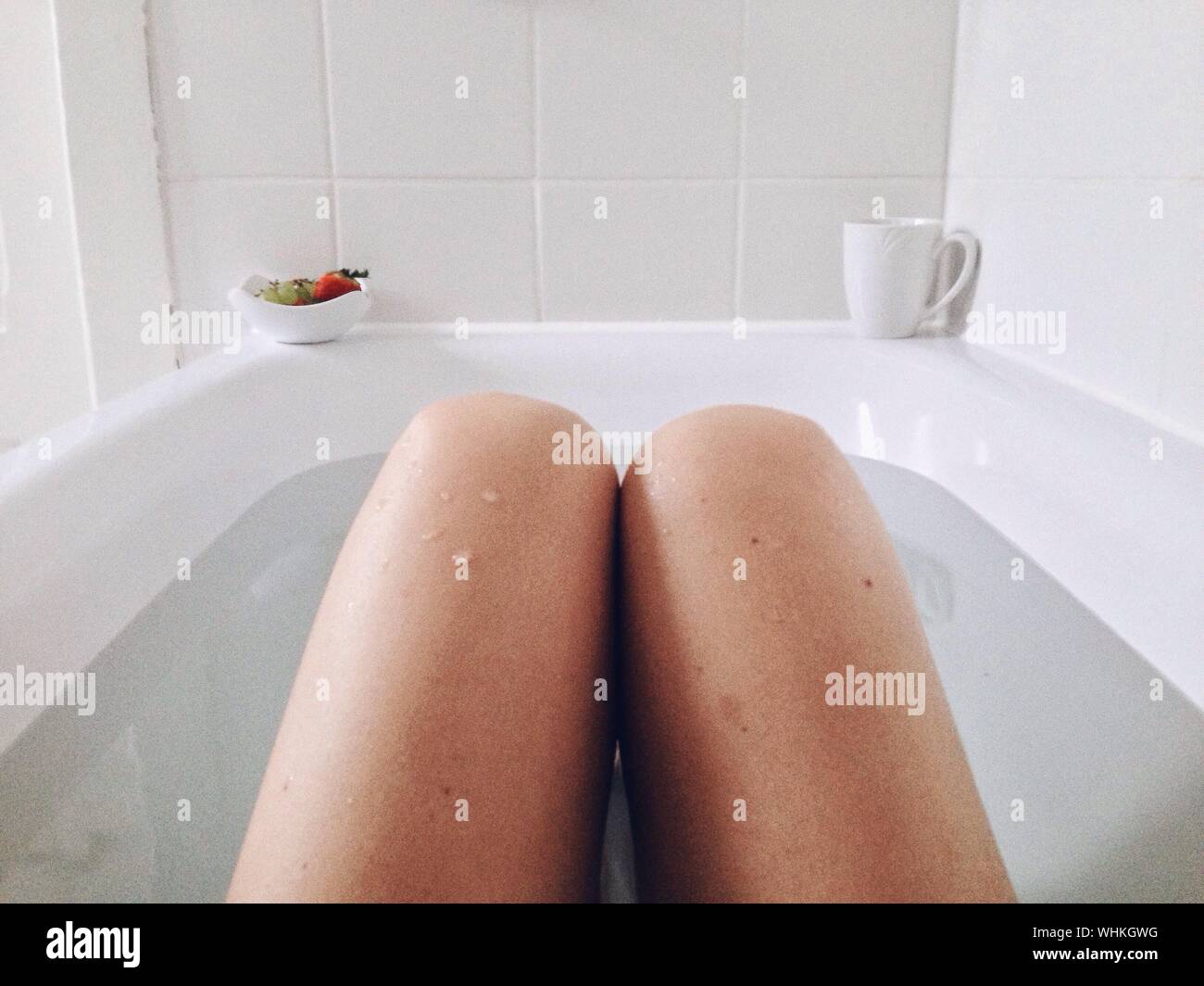 Sección media de la mujer bañándose en la bañera Fotografía de stock - Alamy