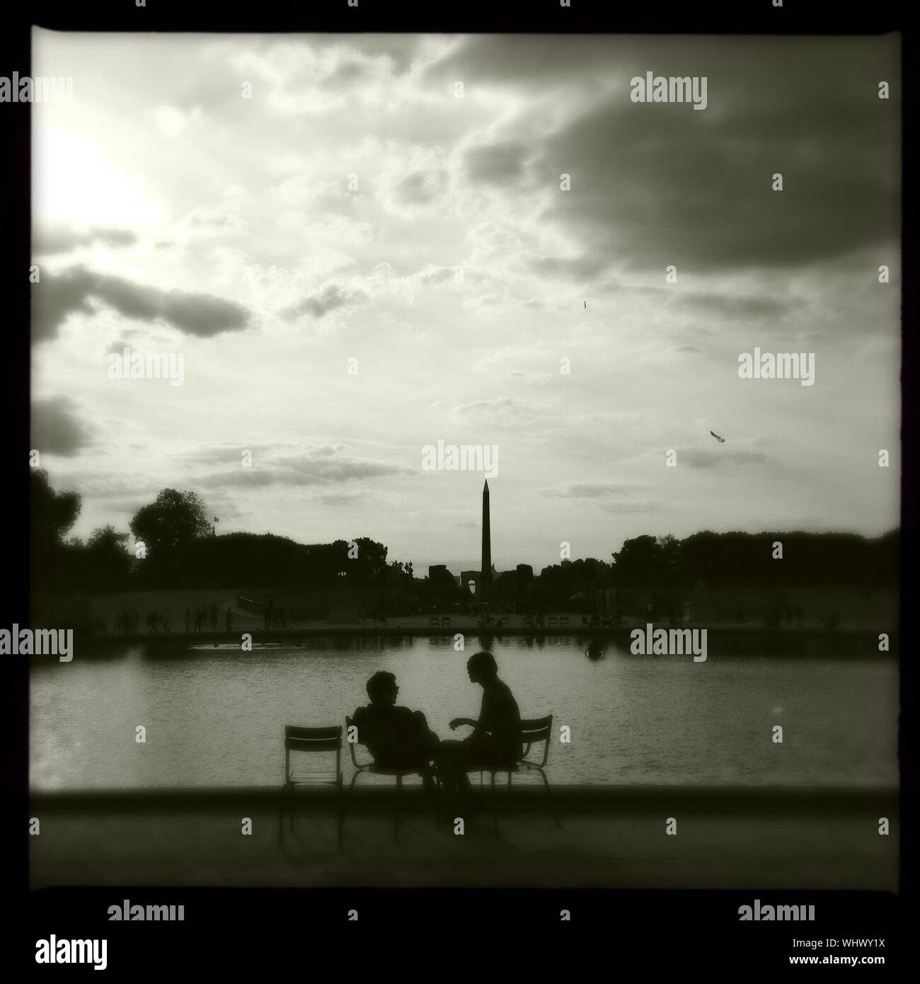 Hombres y mujeres comunicarse unos con otros en el Jardín de las Tuileries contra Sky Foto de stock