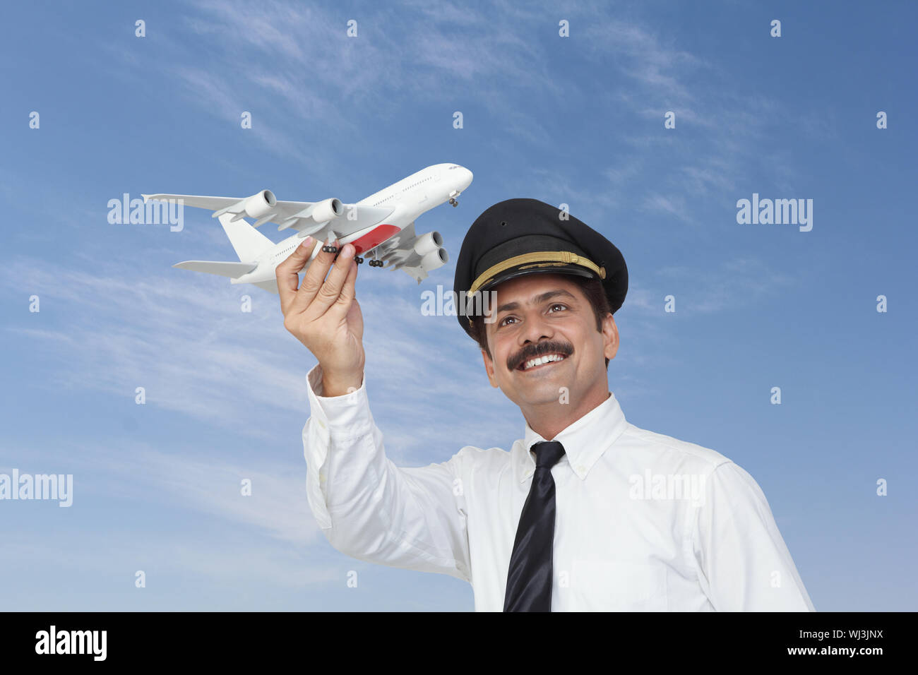 Piloto de vuelo modelo de avión y sonriendo Fotografía de stock - Alamy