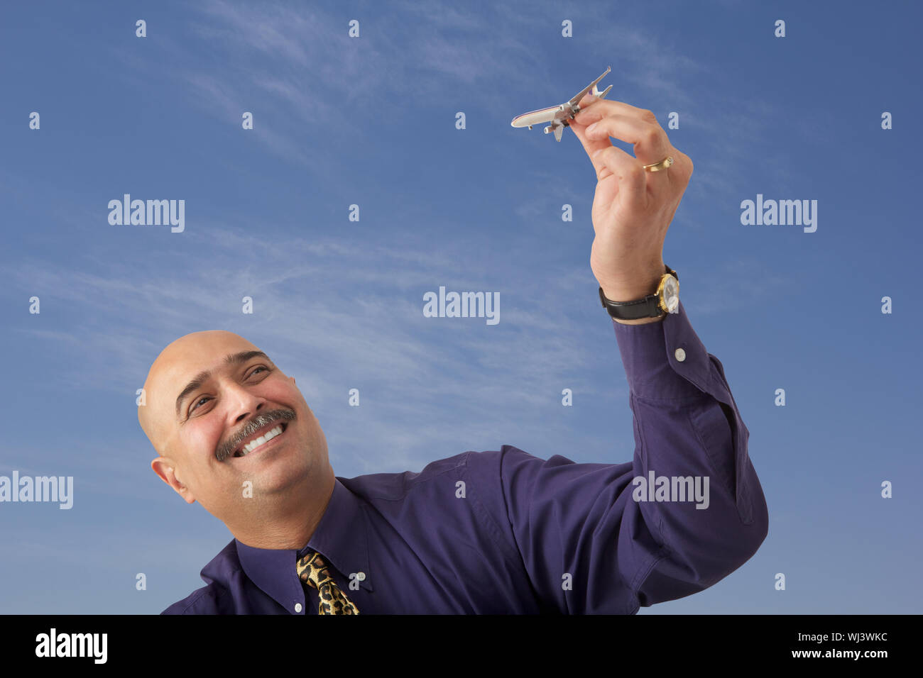 Hombre de negocios jugando con el avión modelo y sonriendo Foto de stock