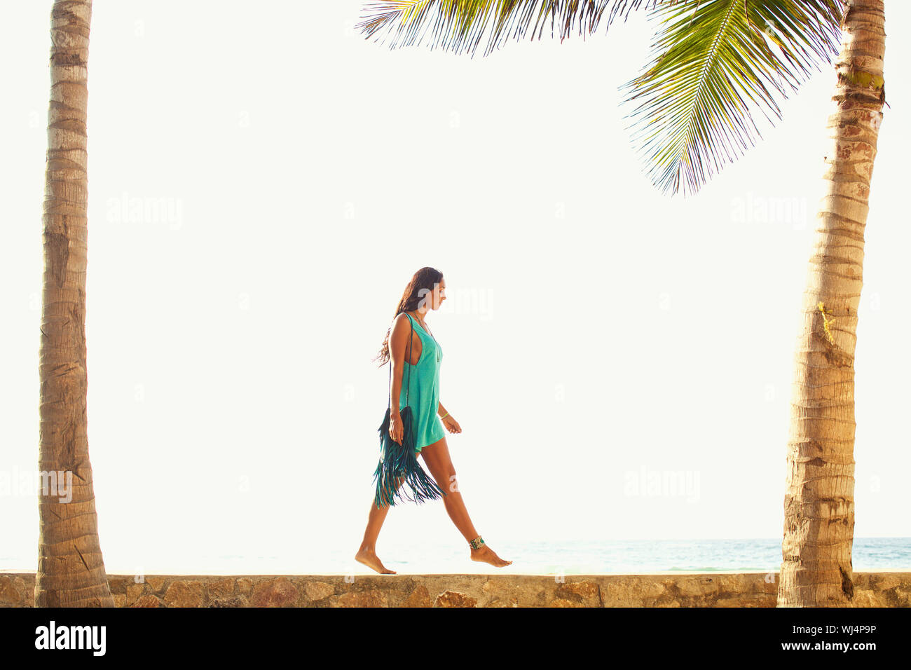 Mujer caminando sunny ocean cornisa Foto de stock
