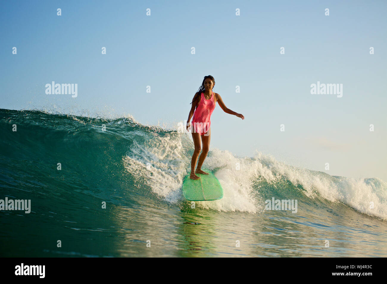 Surfer femenina montando las olas del océano Foto de stock