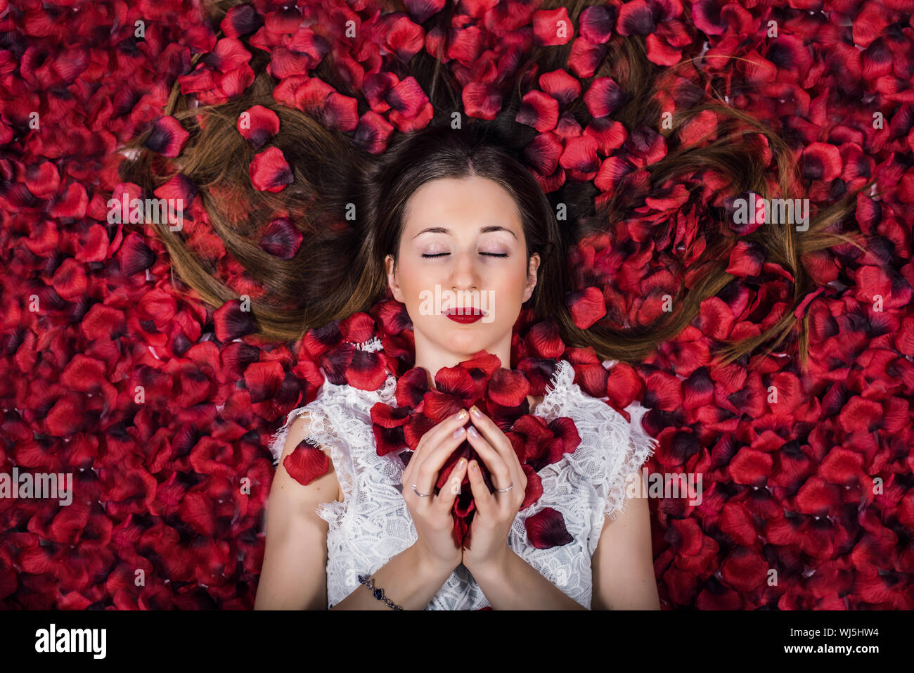 Directamente encima de foto de mujer acostada sobre Pétalos de Rosas Foto de stock