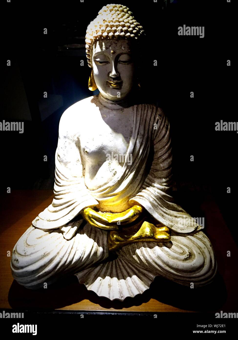 Estatuto de Buda sobre la mesa Foto de stock