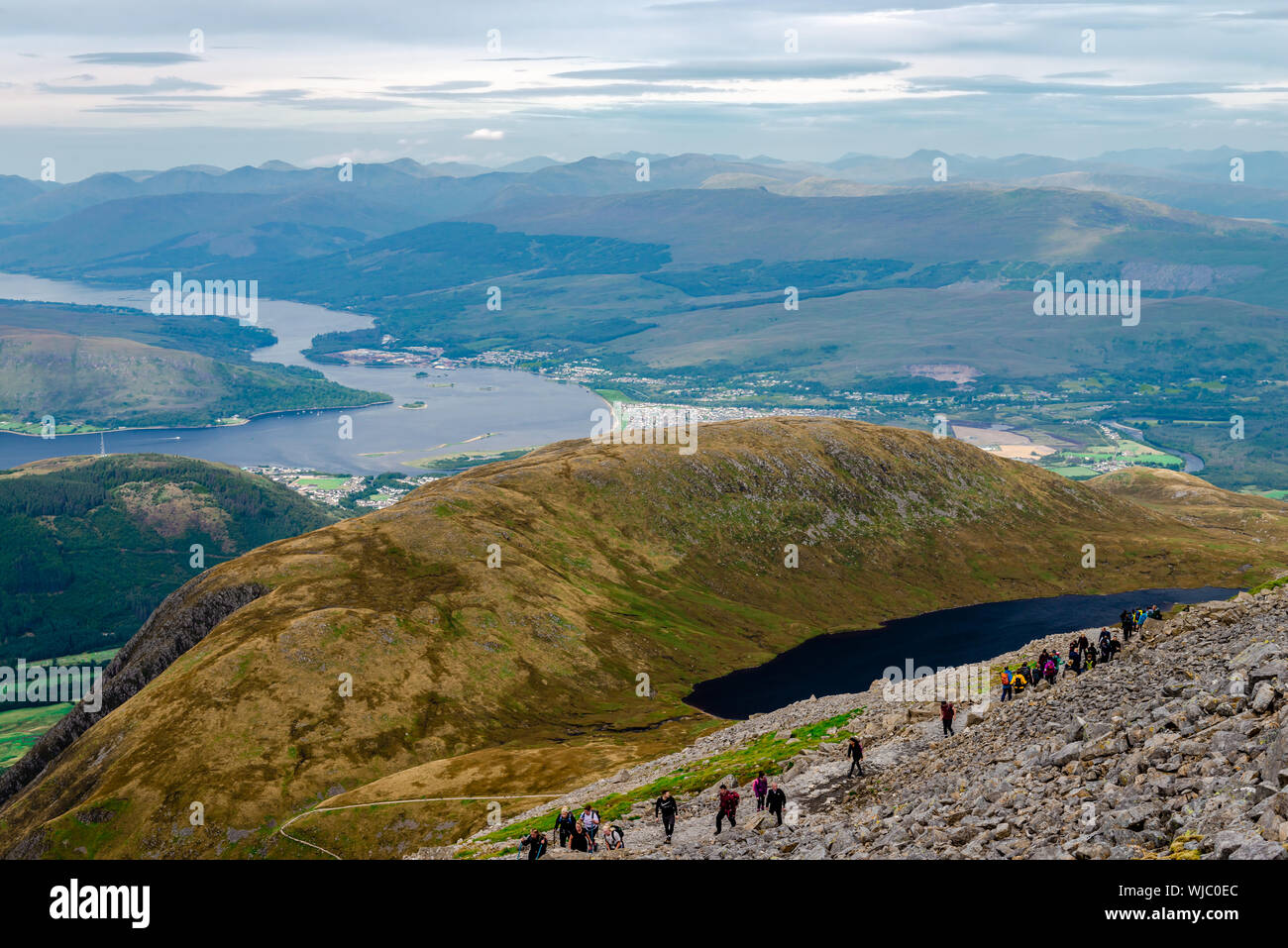La gente alza en el Ben Nevis. Fort William (y algunos otros pueblos de Escocia), Loch Linnhe y Loch Eil son en el fondo. Foto de stock