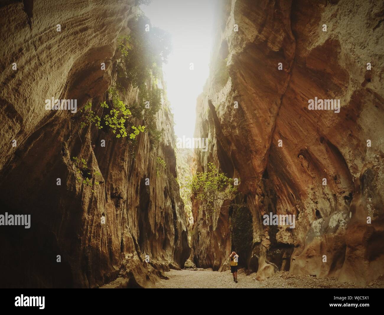 Caminante caminar en medio de formaciones rocosas en el Torrente de Pareis Foto de stock