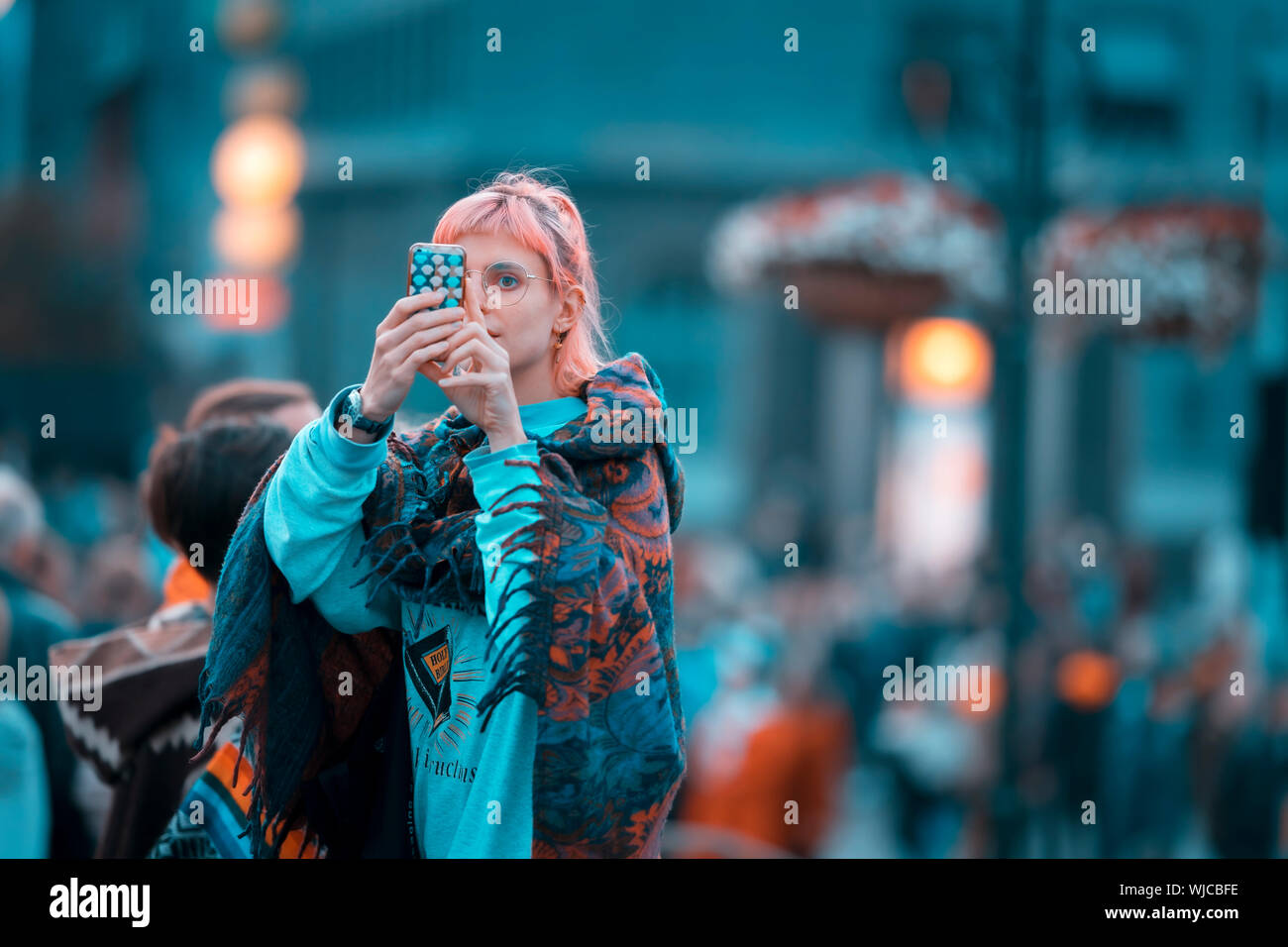 Chica tomando una fotografía con un teléfono inteligente, o Menningarnott Día Cultural, Reykjavik, Iceland. Foto de stock