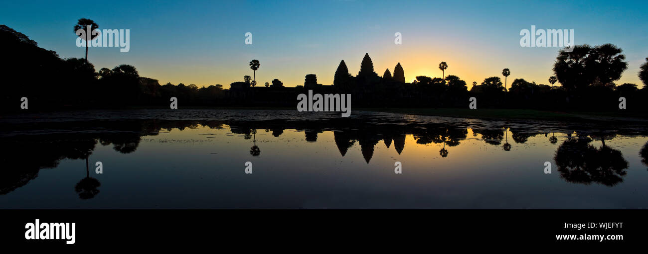 Silueta de antiguas ruinas, reflejada en el agua al atardecer. Foto de stock