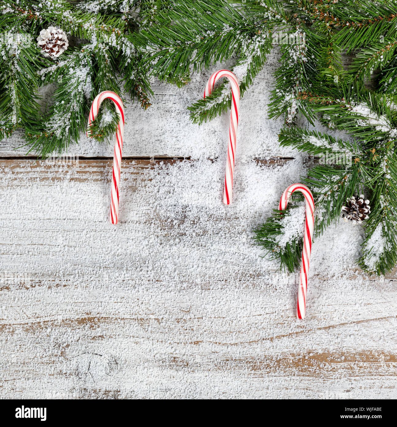 Directamente encima de golpe de bastones de caramelo y ramitas con falsa  nieve en mesa Fotografía de stock - Alamy