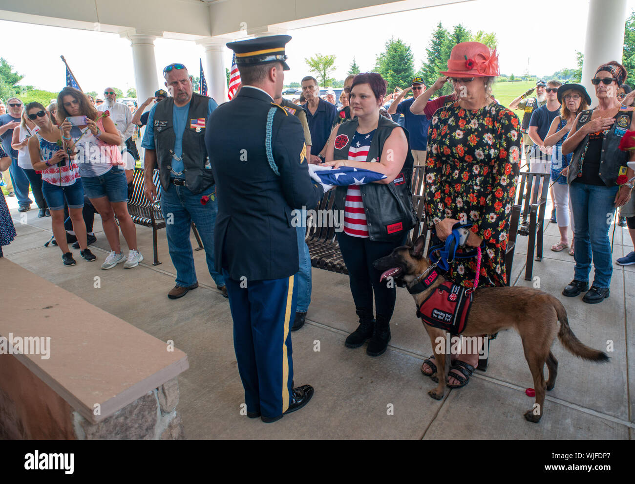 El Sgt. Thomas Morris (a la izquierda) de la Pennsylvania las honras fúnebres militares programa presenta la bandera americana que tapaba la urna a la enfermera Jennife Foto de stock